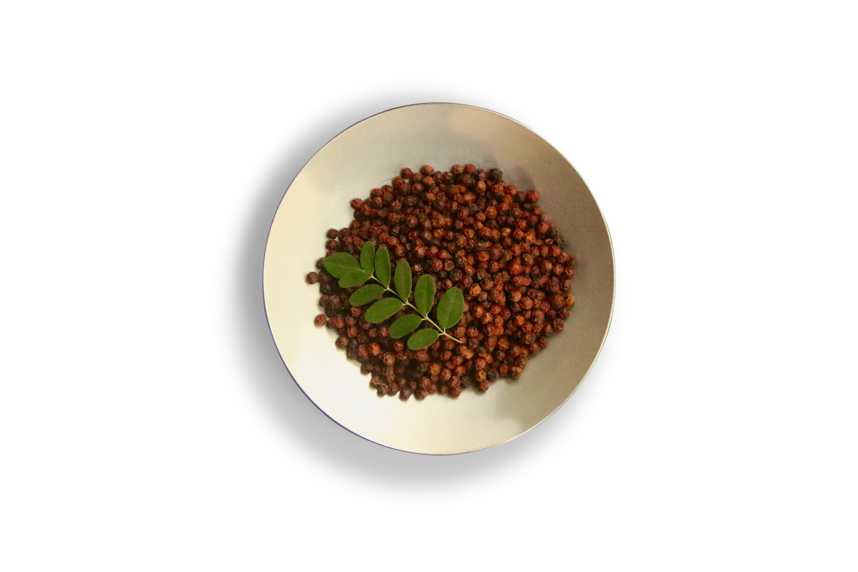 Bowl of red pepper with a moringa leaf on top